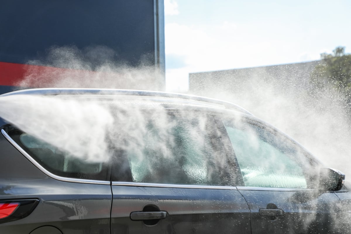 Car being thoroughly cleaned with high-pressure jet showing professional car care results