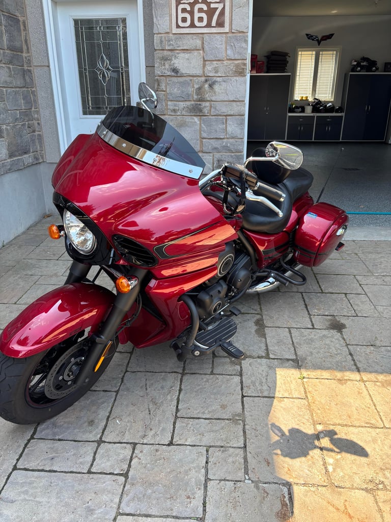 Red motorcycle with sidecar parked on driveway in front of house number 667